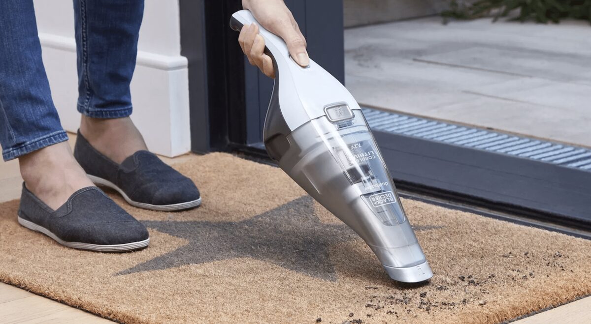 Aspirateur à main Black+Decker sur un paillasson d'entrée