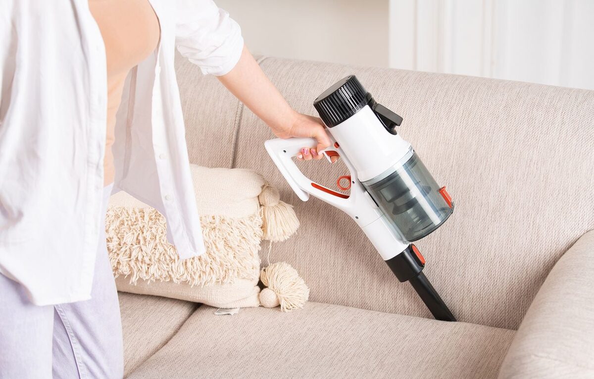 Aspirateur à main sans fil nettoyant un canapé en tissu