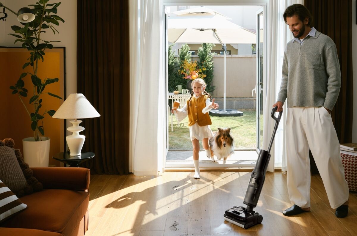 Personne nettoyant le sol pendant qu'un enfant rentre avec le chien de la famille